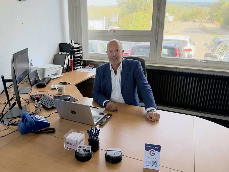 Der Inhaber von MAX Automobile an seinem Schreibtisch im Büro